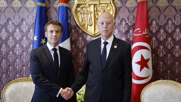 الرئيس الفرنسي، إيمانويل ماكرون، ونظيره التونسي، قيس سعيد، يتصافحان قبل اجتماع ثنائي بينهما خلال قمة البلدان الفرنكوفونية الـ18 في جربة، تونس، 19 نوفمبر/ تشرين الثاني 2022 - سبوتنيك عربي