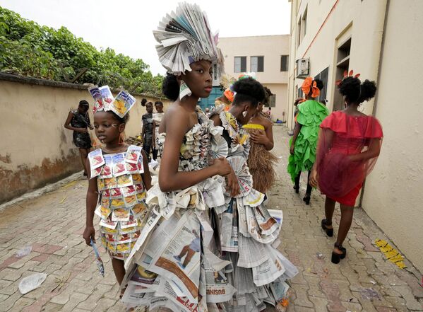 عارضون يرتدون ملابس مصنوعة من مواد مختلفة معاد تدويرها ينتظرون وراء الكواليس قبل عرض القمامة في سانغوتيدو لاغوس، نيجيريا، 19 نوفمبر 2022. - سبوتنيك عربي