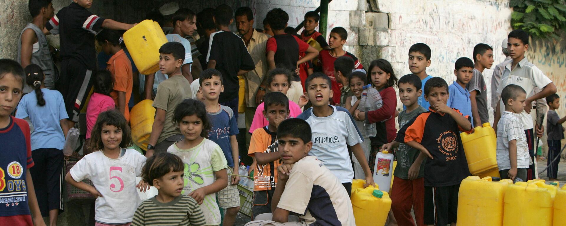 أطفال فلسطينيون ينتظرون تعبئة المياه النظيفة من الأنابيب في خان يونس، جنوب قطاع غزة، 4 سبتمبر/ أيلول 2007 - سبوتنيك عربي, 1920, 15.10.2023