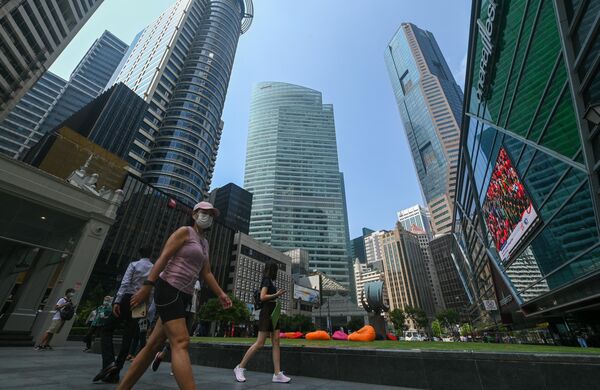 المشاة يسيرون أسفل مباني المكاتب الشاهقة في منطقة الأعمال المالية في رافلز بليس في سنغافورة في 8 أغسطس 2022. - سبوتنيك عربي