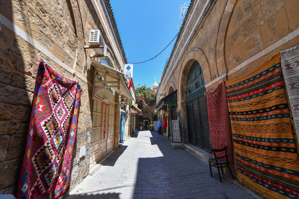 عرض السجاد التقليدي على الجدران حول متجر في الشوارع الضيقة لمدينة تونس القديمة، في 21 مايو 2022. - سبوتنيك عربي