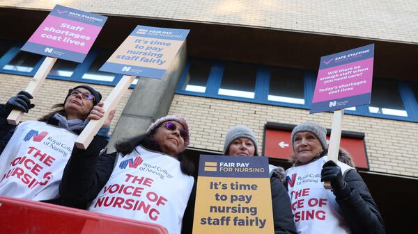 عمال الرعاية الصحية يحملون لافتات أثناء مشاركتهم في إضراب خارج مستشفى سانت ماري في لندن - سبوتنيك عربي