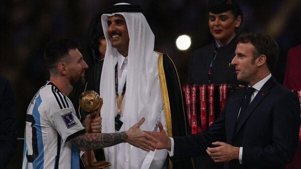 ميسي يتلقى التحية من أمير قطر الشيخ تميم بن حمد، والرئيس الفرنسي إيمانويل ماكرون، بعد فوزه بجائزة أفضل لاعب في كأس العالم 2022 - سبوتنيك عربي