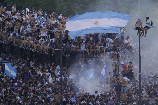 يحتفل مشجعو كرة القدم الأرجنتينية بفوز فريقهم في كأس العالم على فرنسا في بوينس آيرس، الأرجنتين، 18 ديسمبر 2022. - سبوتنيك عربي