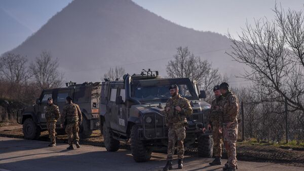 جنود إيطاليون يخدمون في بعثة حفظ السلام الدولية التي يقودها الناتو في كوسوفو بالقرب من طريق محصن بالشاحنات من قبل الصرب في قرية روداري بالقرب من بلدة زفيكان، 26 ديسمبر 2022 - سبوتنيك عربي