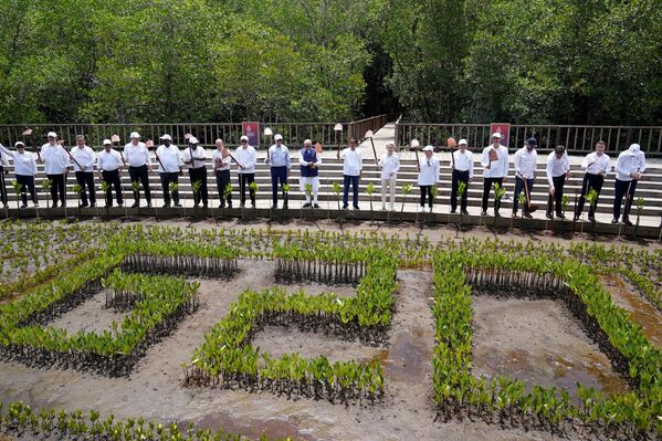 قادة مجموعة العشرين يرفعون مجرفة حديقتهم لالتقاط صورة جماعية خلال حدث غرس الأشجار في غابة تامان هوتان رايا نغوراه راي مانغروف، على هامش اجتماع قمة مجموعة العشرين في نوسا دوا، في منتجع جزيرة بالي الإندونيسية في 16 نوفمبر 2022. - سبوتنيك عربي