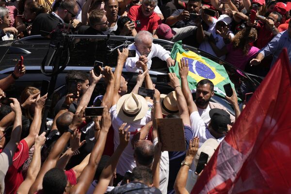 الرئيس البرازيلي السابق لويز إيناسيو لولا دا سيلفا، وسط الصورة، الذي يترشح للرئاسة مرة أخرى، يمسك بيد مؤيد بعد التصويت في جولة الإعادة للانتخابات الرئاسية في ساو باولو، البرازيل، 30 أكتوبر 2022. - سبوتنيك عربي