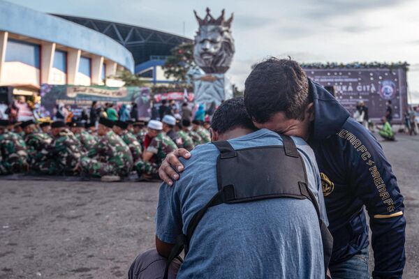 جنود ومدنيون من الجيش الإندونيسي يقدمون احترامهم لضحايا التدافع في ملعب كانجوروهان في مالانج، جاوة الشرقية في 4 أكتوبر 2022. - سبوتنيك عربي