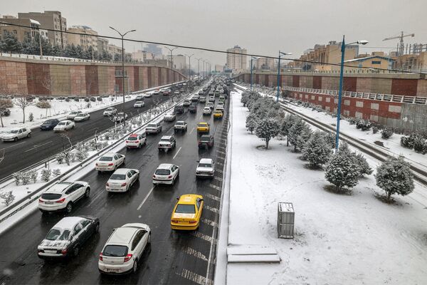 منظر جوي لسيارات تسير على طول أحد الشوارع أثناء تساقط الثلوج في العاصمة الإيرانية طهران في 15 يناير 2023. - سبوتنيك عربي