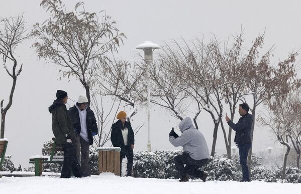 إيرانيون يستمتعون بالتنزه في حديقة أثناء تساقط الثلوج في العاصمة طهران في 15 يناير 2023. - سبوتنيك عربي