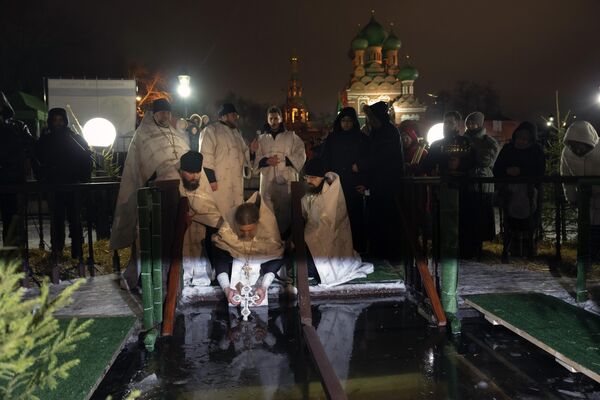 كاهن أرثوذكسي روسي يبارك الماء الجليدي في عيد الغطاس خلال عيد الغطاس التقليدي في كنيسة الثالوث المقدس في أوستانكينو بالقرب من برج التلفزيون في موسكو، روسيا، 18 يناير 2023. - سبوتنيك عربي