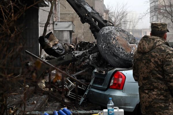 عسكري يقف في الموقع الذي تحطمت فيه مروحية بالقرب من روضة أطفال خارج العاصمة كييف، مما أسفر عن مقتل 16 شخصًا، بينهم طفلان ووزير الداخلية الأوكراني، أوكرانيا 18 يناير 2023. - سبوتنيك عربي