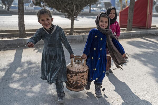 فتيات أفغانيات يحملن أسطوانة غاز في أحد شوارع كابول، أفغانستان 17 يناير 2023. - سبوتنيك عربي