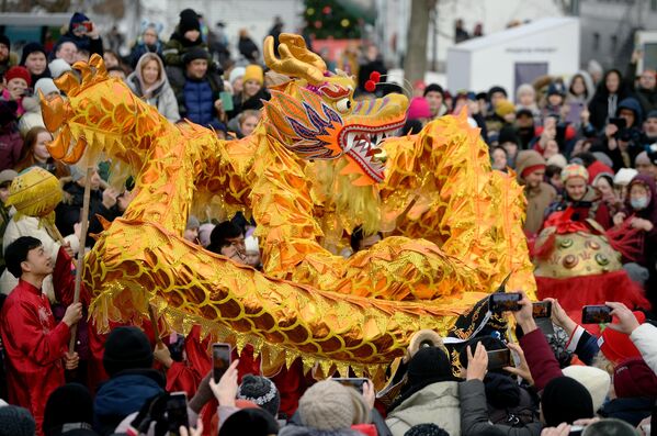 فنانون يرتدون أزياء وطنية يحملون تنينًا طوله 18 مترًا خلال احتفالات رأس السنة الصينية في في دي إن خا في موسكو، روسيا 21 يناير 2023 - سبوتنيك عربي