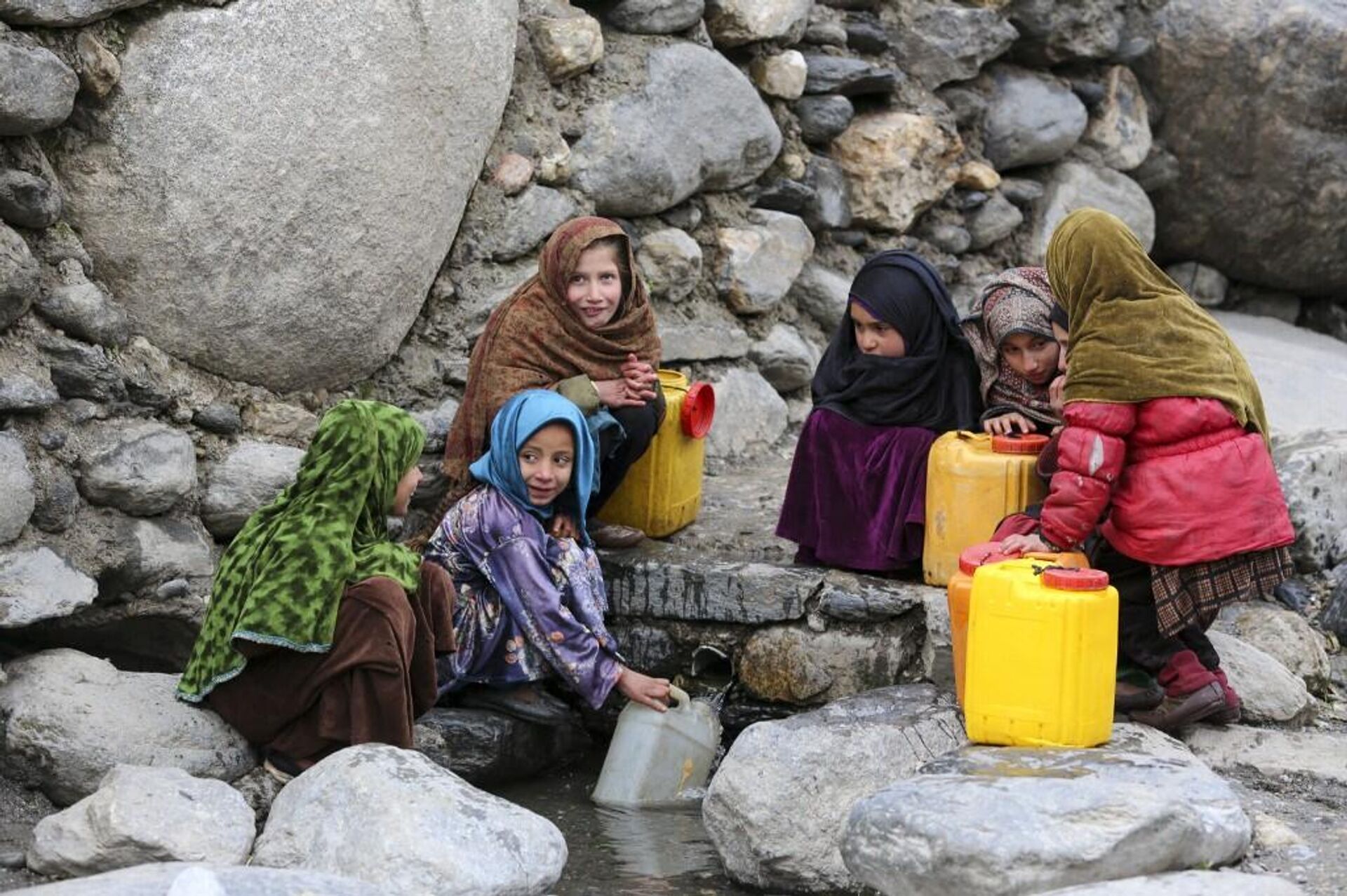 فتيات أفغانيات صغيرات في أثناء شرب المياه في إحدى مناطق أفغانستان، 23 يناير/ كانون الثاني 2023 - سبوتنيك عربي, 1920, 08.02.2023