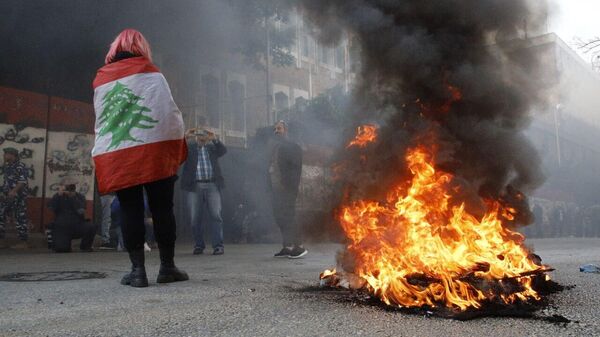 متظاهرون يشعلون الإطارات أمام المدخل الرئيسي لمصرف لبنان ويرشقونه بالحجارة، احتجاجًا على التدهور الكبير لليرة اللبنانية أمام الدولار - سبوتنيك عربي