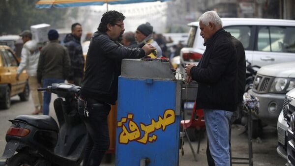 رجل يعمل على تبديل العملات في أحد شوارع بغداد، 27 ديسمبر/ كانون الأول 2023 - سبوتنيك عربي