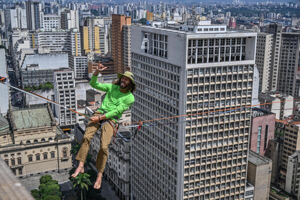 متسلق الحبال البرازيلي، رافاييل بريدي، يحتفل بعد انتهاء العرض الذي قدمه على حبل مشدود بارتفاع 114 مترًا وطوله 510 أمتار، وعبر كامل وادي دو أنهانغابو، كجزء من الذكرى الـ469 لتأسيس مدينة ساو باولو بالبرازيل في 25 يناير 2023 - سبوتنيك عربي