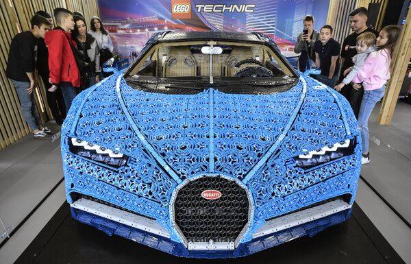 زوار يتفقدون سيارة بوغاتي تشيرون (Bugatti Chiron) بحجمها الطبيعي، وقابلة للقيادة مصنوعة من قطع الليغو، LEGO Technic، في معرض في حديقة غوركي في موسكو، روسيا 23 يوليو 2019. - سبوتنيك عربي