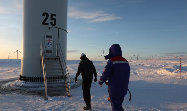 موظفون بالقرب من إحدى توربينات الرياح في محطة كولسكايا لتوليد الطاقة الكهربائية في كولسكايا في منطقة مورمانسك شمالي روسيا - سبوتنيك عربي