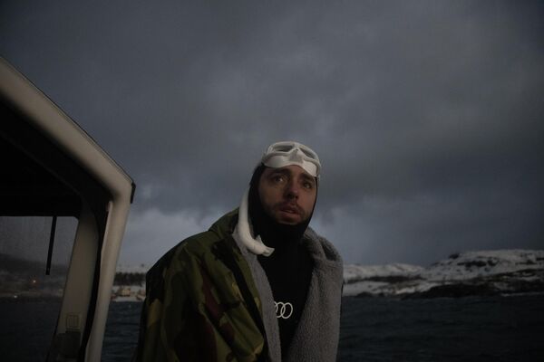 ينظر الفرنسي آرثر جويرين بويري، بطل العالم المحرر خمس مرات، من القارب قبل أن يغوص في العمق لاكتشاف حيتان &quot;أوكرا&quot; (الحوت القاتل)، في جزيرة سبيلدرا شمال الدائرة القطبية الشمالية، في 25 يناير 2023. - سبوتنيك عربي