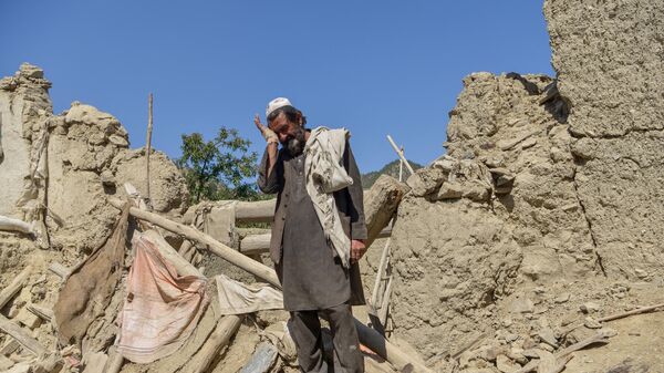 Мужчина на руинах дома, разрушенного после землетрясения в районе Гайан, Афганистан, июнь 2022  - سبوتنيك عربي