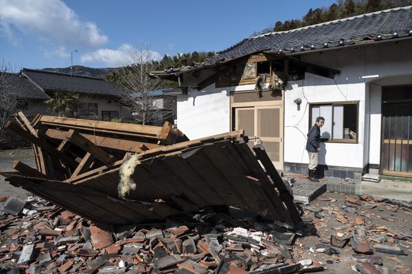 صانع السوشي أكيو هانزاوا يسير أمام مطعمه المتضرر في شيروشي بمقاطعة مياجي في 17 مارس 2022، بعد زلزال بقوة 7.3 درجة ضرب شرق اليابان في الليلة السابقة. - سبوتنيك عربي