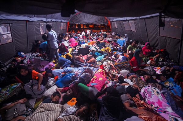 الناس يتجمعون في خيمة لتجنب توابع الزلزال في غرب باسامان ، مقاطعة سومطرة الغربية بإندونيسيا في 26 فبراير 2022، بعد يوم من زلزال بقوة 6.2 درجة ضرب المنطقة. - سبوتنيك عربي