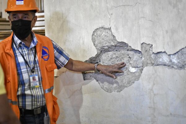 أحد أعضاء منسق الحد من الكوارث يظهر جدارًا متضررًا في كنيسة سان خوان أوبيسبو، في أعقاب الزلزال الذي ضرب المنطقة 6.2 درجة في أماتيتلان، على بعد 35 كيلومترًا جنوب مدينة غواتيمالا، في 16 فبراير 2022.  زلزال بقوة 6.2 درجة ضربت منطقة غرب جواتيمالا في ساعة مبكرة من صباح ذلك اليوم، بحسب هيئة المسح الجيولوجي الأمريكية، على الرغم من عدم الإبلاغ عن وقوع إصابات حتى الآن. - سبوتنيك عربي