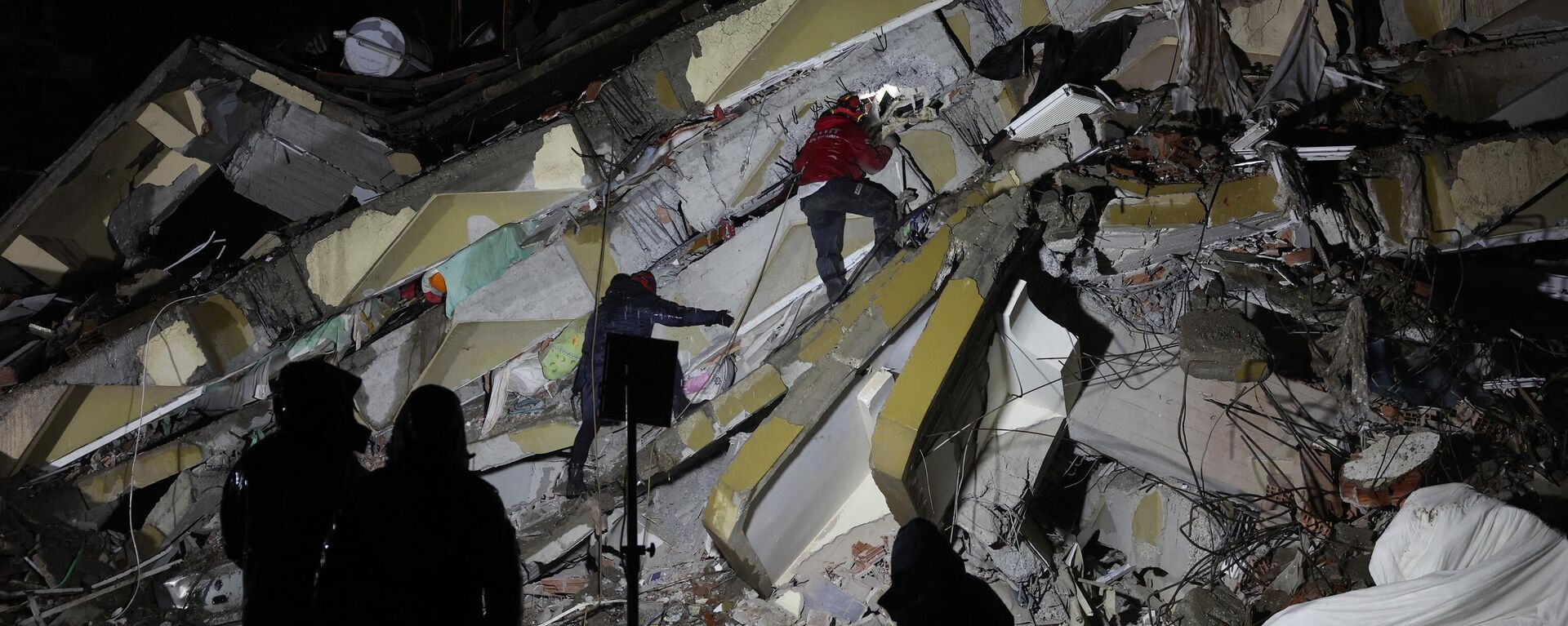 يبحث رجال الإنقاذ عن الضحايا والناجين وسط أنقاض المباني المنهارة في كهرمان ماراش ، تركيا ، بعد زلزال بقوة 7.8 درجة ضرب جنوب شرق البلاد في 7 فبراير 2023. - سبوتنيك عربي, 1920, 12.02.2023
