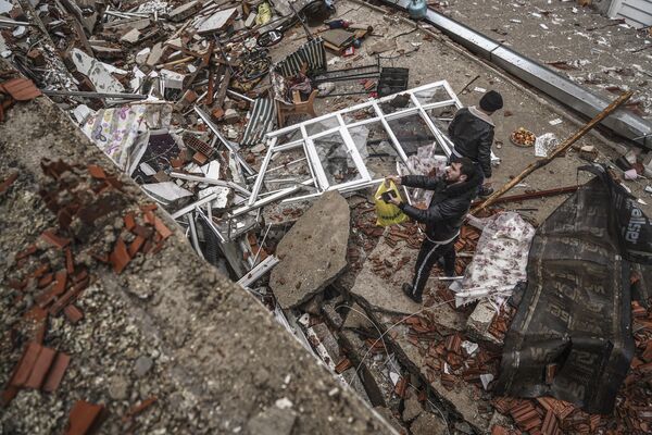 يبحث الناس وفرق الطوارئ عن أشخاص تحت الأنقاض في مبنى مدمر في غازي عنتاب، تركيا، 6 فبراير/شباط 2023، تسبب زلزال قوي في تدمير العديد من المباني في تركيا وسوريا ويخشى وقوع العديد من الضحايا. - سبوتنيك عربي