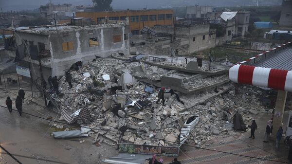 أشخاص يفتشون مبنى منهارًا في أعقاب الزلزال الذي وقع في بلدة أزمارين بمحافظة إدلب شمال سوريا، 6 فبراير 2023 - سبوتنيك عربي