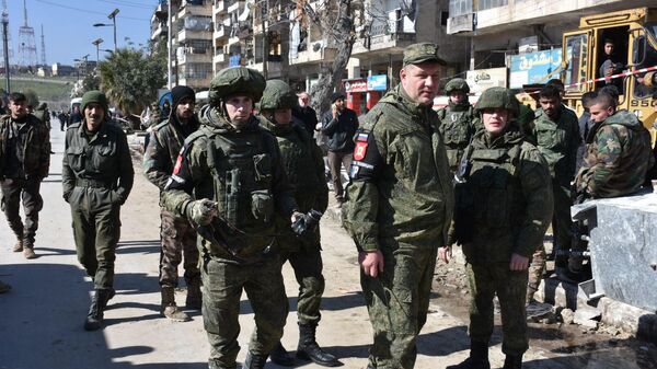 جنود الجيش الروسي ينتشلون  أشخاص أحياء من تحت أنقاض أحد الأبنية في منطقة المشارقة بمدينة حلب، سوريا - سبوتنيك عربي
