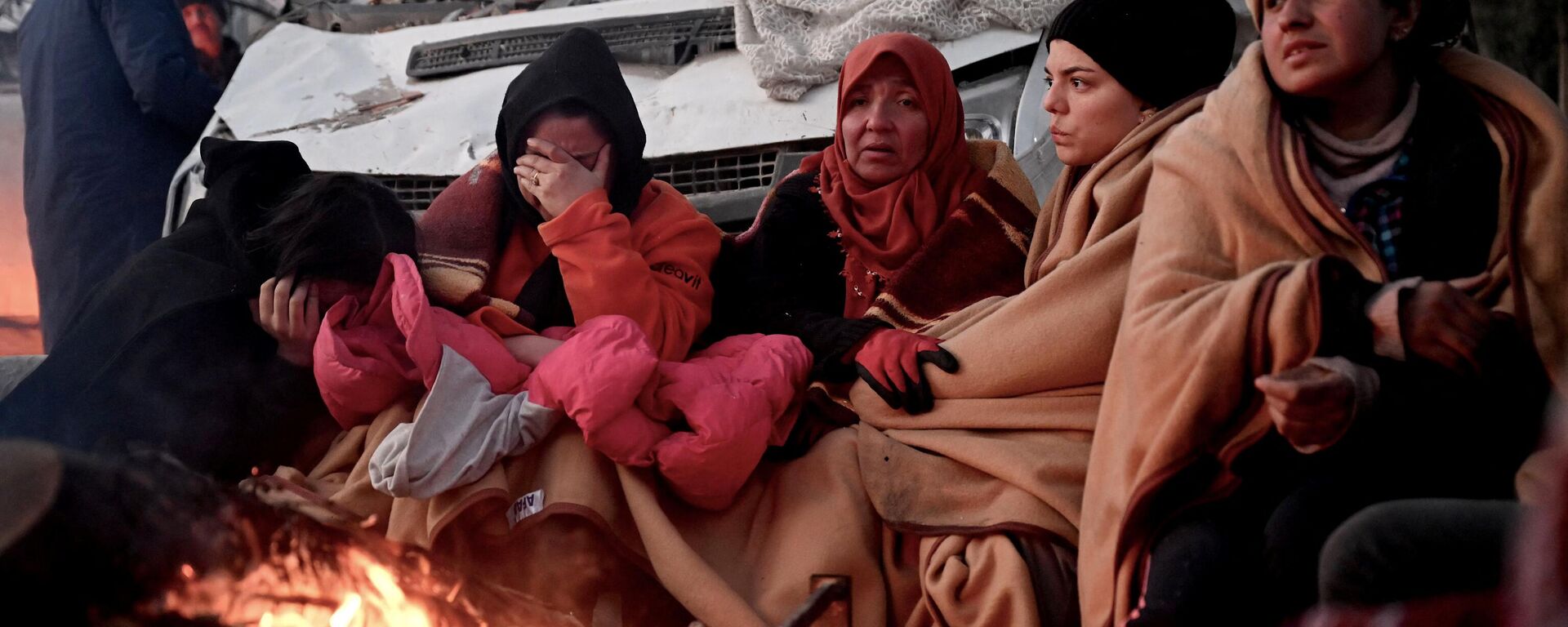 أشخاص يجلسون بالقرب من نار وسط أنقاض المباني المنهارة في قهرمان مرعش ، في 8 فبراير 2023 ، بعد يومين من وقوع زلزال بقوة 7.8 درجة على مقياس ريختر في جنوب شرق تركيا. - سبوتنيك عربي, 1920, 18.02.2023