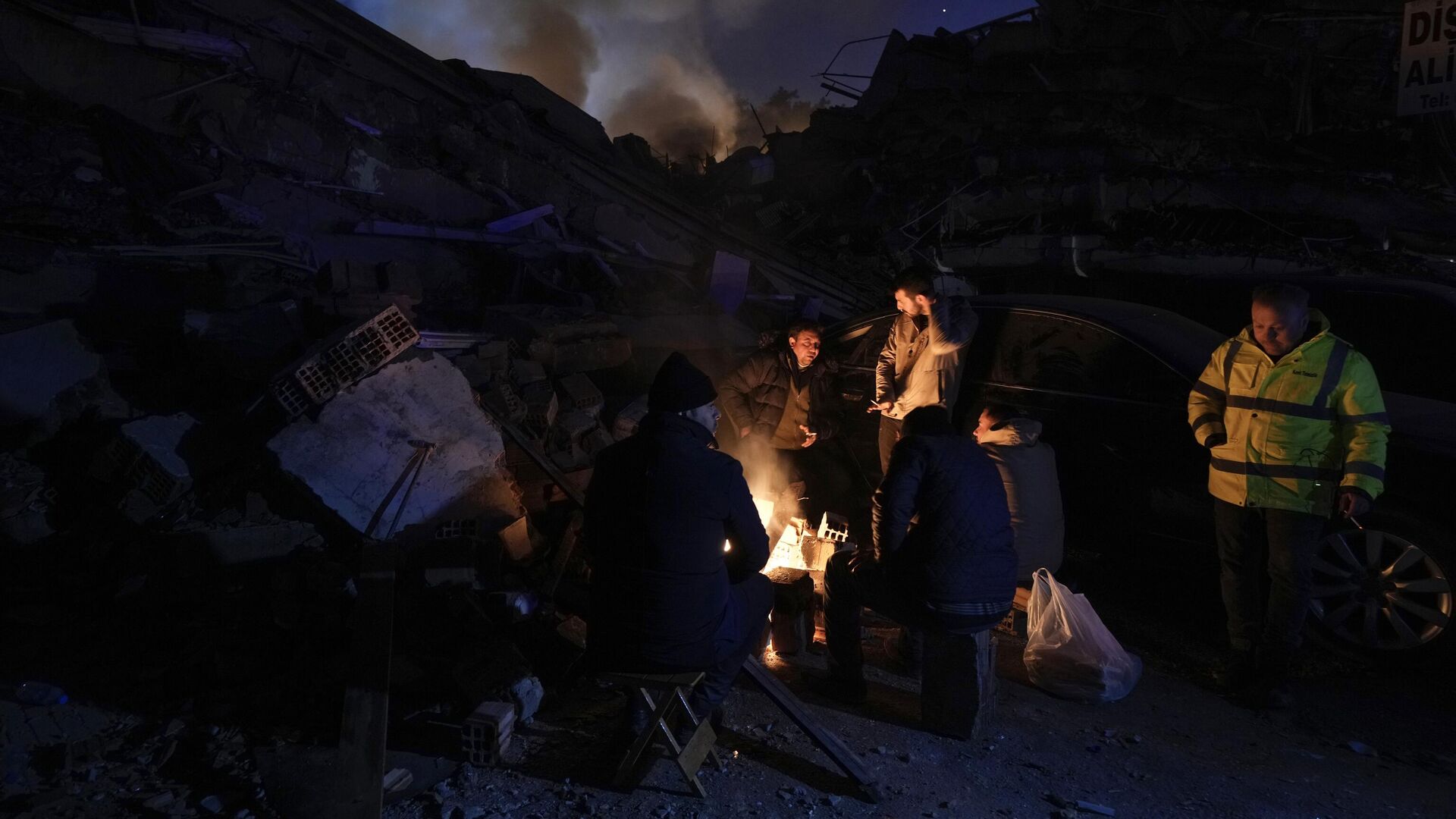 الناس يسخنون بالنيران أمام المباني المدمرة في أنطاكيا ، جنوب تركيا ، 8 فبراير ، 2023.  - سبوتنيك عربي, 1920, 14.03.2023