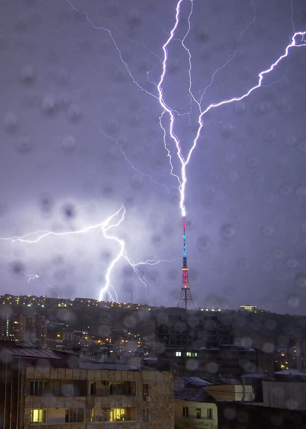 في هذه الصورة التي تم التقاطها من خلال نافذة مغطاة بقطرات المطر، يضرب البرق برج تلفزيون في يريفان، عاصمة أرمينيا يوم 4 أكتوبر 2020. - سبوتنيك عربي