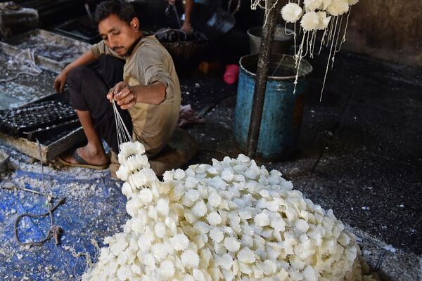 يقوم أحد العمال بإعداد أكاليل من حلوى السكر قبل مهرجان هولي الهندوسي في أحمد آباد، الهند 1 مارس 2023. - سبوتنيك عربي