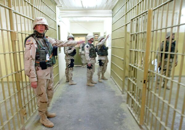 يراقب الجنود الأمريكيون عن كثب، حيث سُمح لصحفي بزيارة بعض أجزاء سجن أبو غريب وتصويرها في 10 مايو/ أيار 2004. يُحتجز قي هذا السجن معتقلون ذوو خطورة عالية. وكانت قد أسفرت تقارير صحفية حول الانتهاكات في السجن عن إيقاف عمل القائد العام وتوجيه التهم إلى عدد من الجنود الأمريكيين. - سبوتنيك عربي