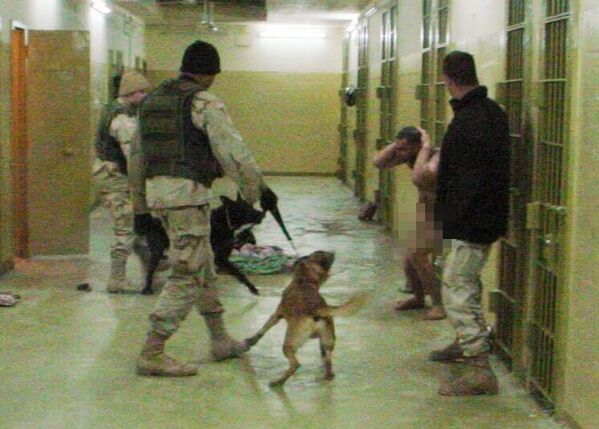 هذه صورة حصلت عليها وكالة &quot;أسوشيتد برس&quot; الأمريكية وتُظهر الرقيب مايكل سميث، إلى اليسار، مع كلبه الأسود ماركو، والرقيب سانتوس كاردونا، الثاني على اليمين، مع كلبه الراعي البلجيكي دوكو، والمحتجز محمد بولينديا والجندي إيفان إل فريدريك الثاني إلى اليمين، في سجن أبو غريب في بغداد، في 12 ديسمبر/ كانون الأول 2003. الرقيب السابق في الجيش الاحتياطي الملقب بـ&quot;تشيب&quot; فريدريك جونيور، الذي أُطلق سراحه يوم الاثنين 1 أكتوبر/ تشرين الأول 2007، من سجن عسكري في فورت ليفنوورث في ولاية كانساس الأمريكية، قضى حوالي ثلاث سنوات من أصل حُكم بالسجن ثماني سنوات بتهمة الإساءة إلى معتقلين في سجن أبو غريب. - سبوتنيك عربي