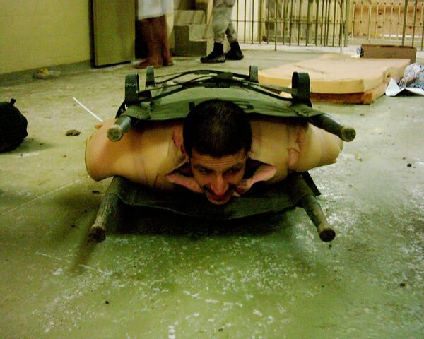 هذه الصورة حصلت عليها &quot;وكالة أسوشيتد برس&quot; تظهر محتجزًا عراقيًا محصورًا بين محفتين (على شكل سندويش) في سجن أبو غريب في بغداد، في أواخر عام 2003. - سبوتنيك عربي