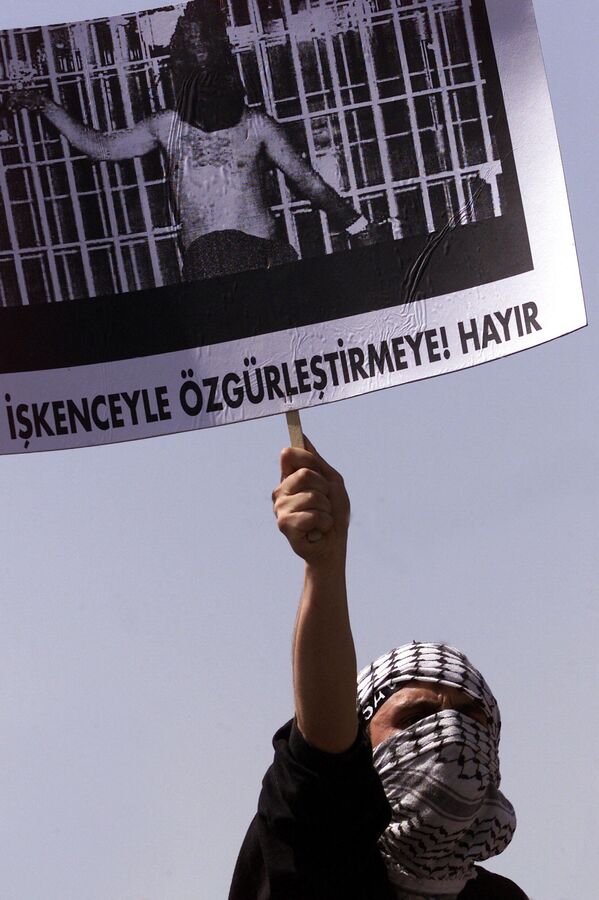 متظاهر يحمل ملصق لصورة سجين عراقي يتعرض للإذلال في سجن أبو غريب ببغداد، خلال مظاهرة ضد الاحتلال الأمريكي للعراق في اسطنبول 9 مايو/ أيار 2004. وتظاهر الآلاف احتجاجا على ما تردد عن تعرض محتجزين عراقيين للتعذيب على أيدي الجنود الأمريكيين. - سبوتنيك عربي