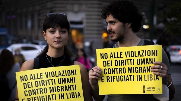 متظاهرون يحملون لافتات كتب عليها لا لانتهاك حقوق الإنسان ضد المهاجرين واللاجئين في ليبيا خلال مظاهرة ضد مذكرة التفاهم الإيطالية الليبية في روما، 26 أكتوبر/ تشرين الأول 2022 - سبوتنيك عربي