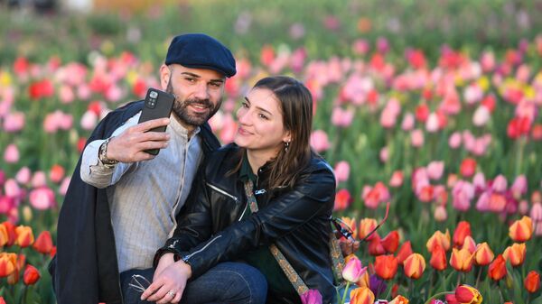 Пара делает селфи в поле тюльпанов в Арезе, Италия - سبوتنيك عربي
