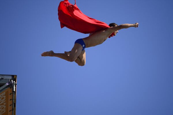 تشيكي ميشال نافراتيل يغوص من أجل المزح، كرجل خارق بعد منافسة نهائيات الغوص العالي للرجال في بطولة العالم للاتحاد الدولي لكرة القدم (FINA) في ميناء مول دي لا فوستا في برشلونة في 31 يوليو 2013. - سبوتنيك عربي