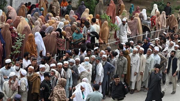 مواطنون ينتظرون في طوابير لجمع أكياس طحين مجانية في نقطة توزيع حكومية في بيشاور، باكستان، 29 مارس/ آذار 2023 - سبوتنيك عربي