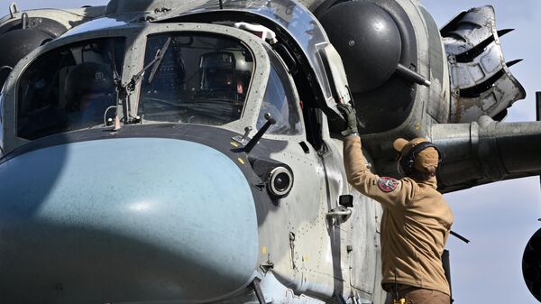 أفراد من الأرض يلتقون بطائرة هليكوبتر من طراز كا-52 تابعة للقوات المسلحة الروسية في منطقة العملية العسكرية الخاصة. - سبوتنيك عربي