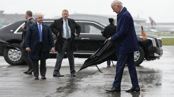 الرئيس جو بايدن يفتح مظلته عند وصوله إلى مطار دبلن الدولي في دبلن ، أيرلندا ، في 12 أبريل 2023. - سبوتنيك عربي