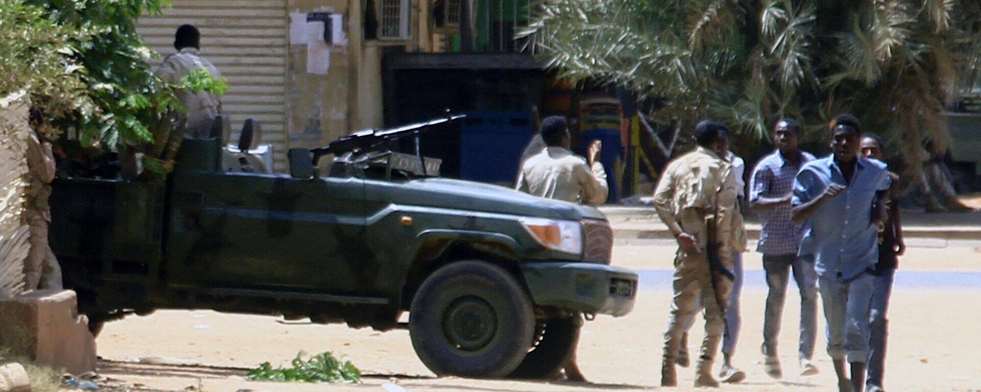 أشخاص يمرون من أمام مركبة عسكرية في الخرطوم في 15 أبريل / نيسان 2023 ، وسط اشتباكات ذكرت في المدينة. - سبوتنيك عربي, 1920, 10.01.2024