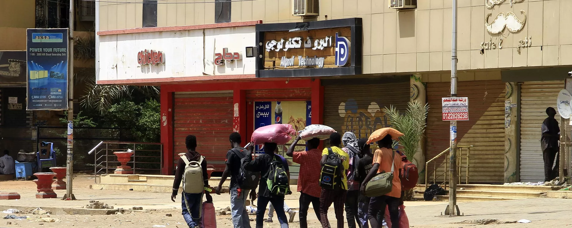 أشخاص يحملون أمتعتهم يسيرون على طول أحد شوارع الخرطوم في 16 أبريل / نيسان 2023 ، مع استمرار القتال بين قوات الجنرالات المتناحرين. - سبوتنيك عربي, 1920, 17.05.2023