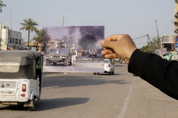 صورة لجنود أمريكيين يؤمنون المنطقة بعد انفجار متفجرات في شارع فلسطين ببغداد يوم 31 ديسمبر 2003، أُدرجت في الموقع نفسه يوم 24 مارس 2023. بعد 20 عامًا من الغزو الذي قادته الولايات المتحدة للعراق. - سبوتنيك عربي